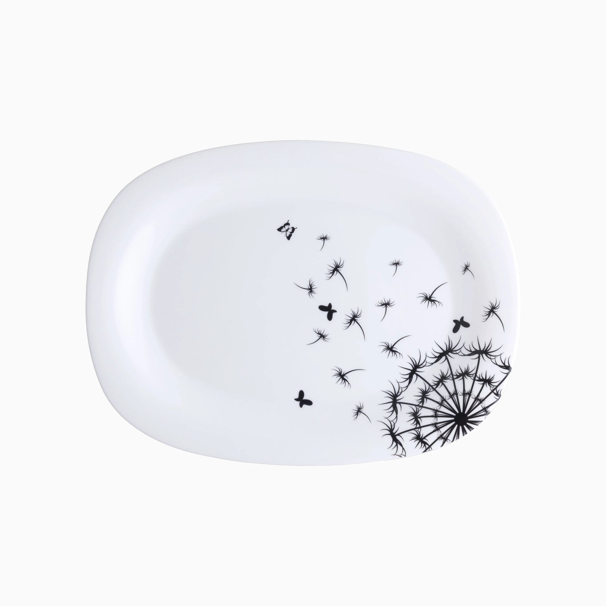 White ceramic plate with black dandelion design on a white background