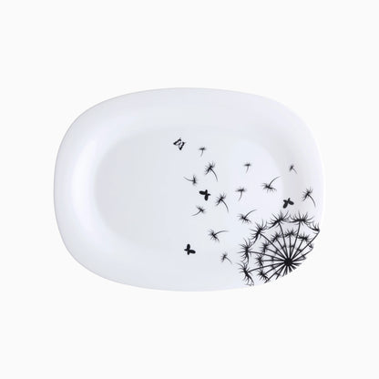 White ceramic plate with black dandelion design on a white background