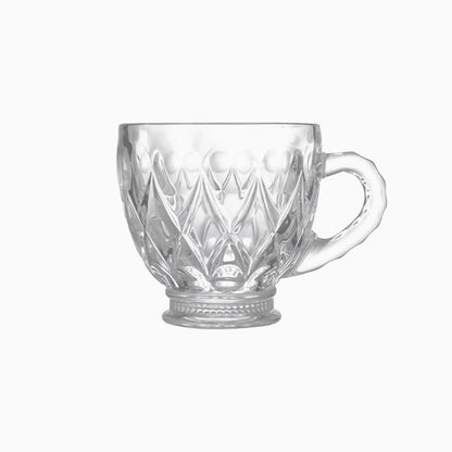 Clear glass mug with diamond cut pattern on a white background