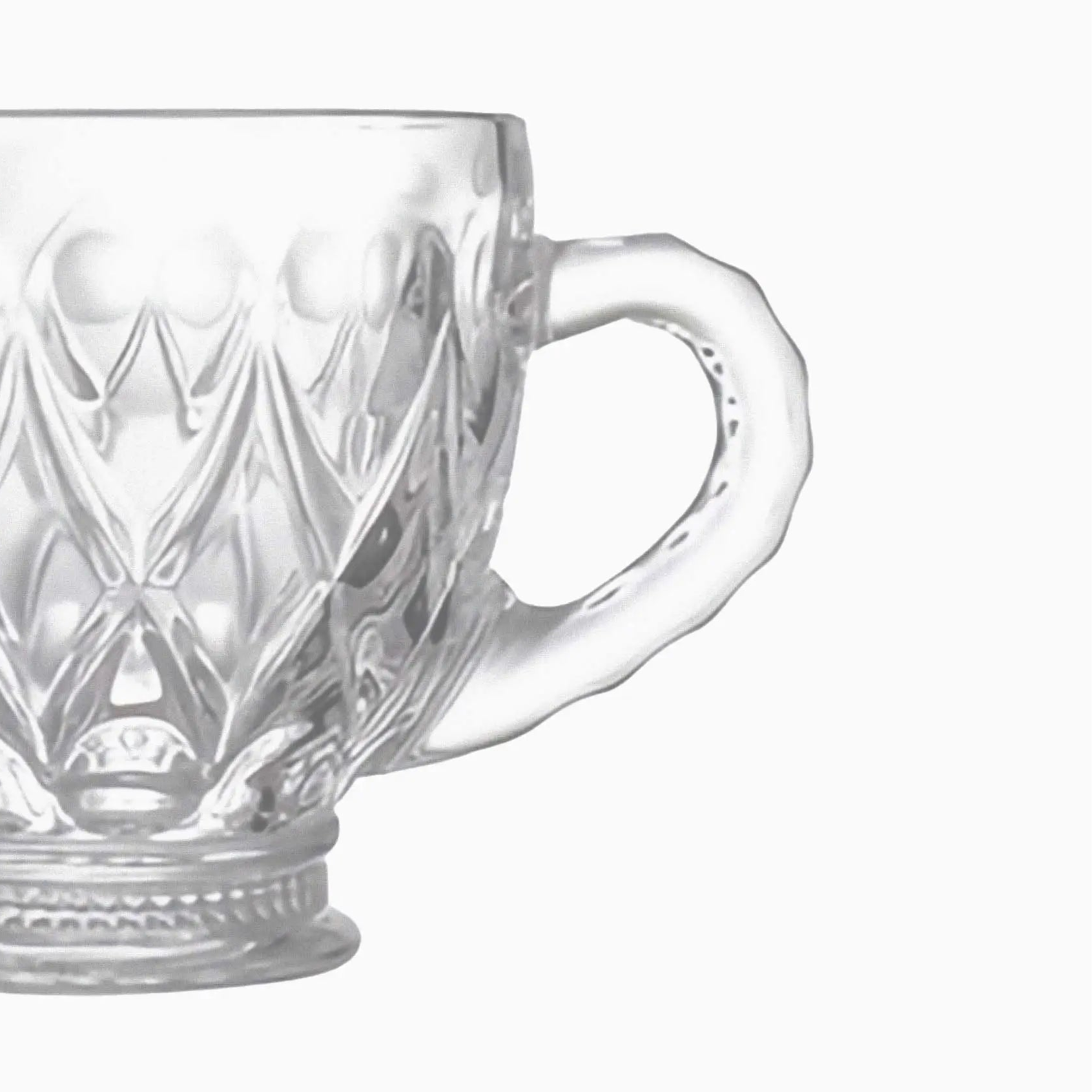 Clear glass mug with intricate patterns on a white background