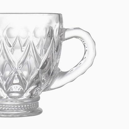 Clear glass mug with intricate patterns on a white background