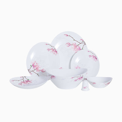 White dinnerware set with pink floral patterns on a white background