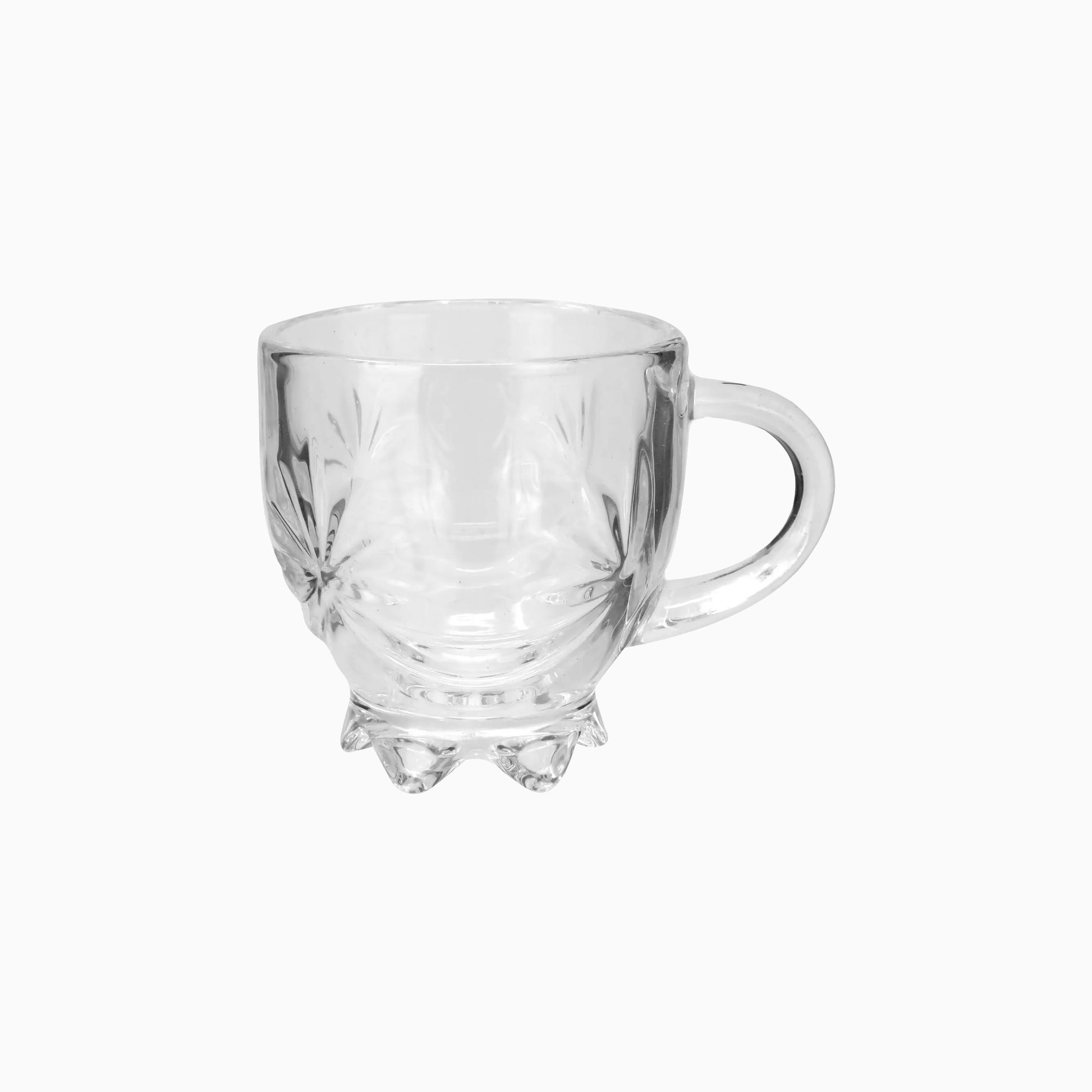 A clear glass cup with a handle and geometric patterns on the side, with a capacity of 5.2 oz.