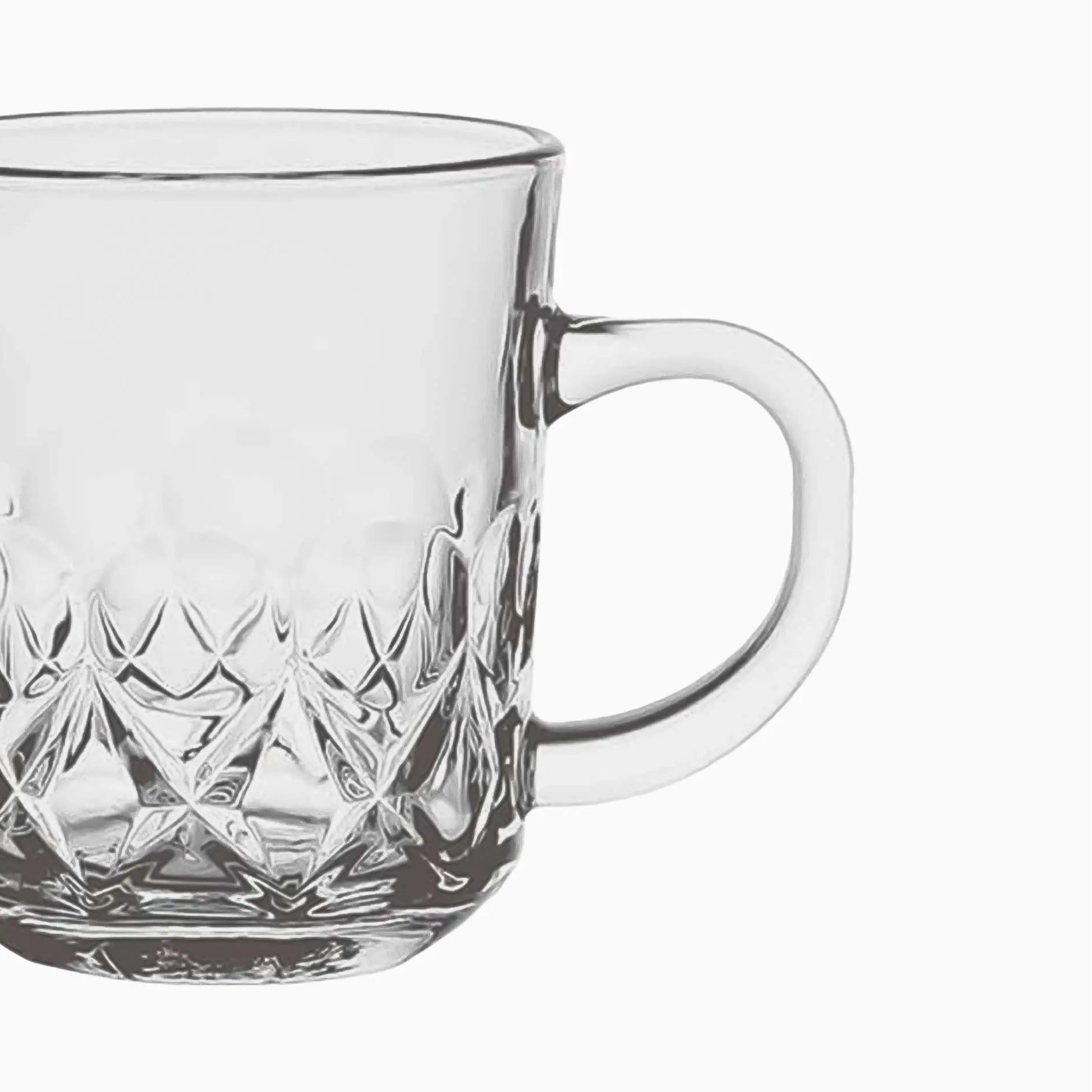 Clear glass mug with diamond cut pattern on a white background
