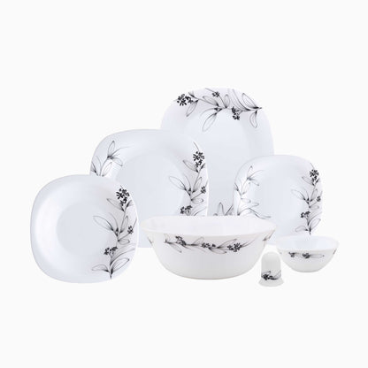 Set of white ceramic dinnerware with black floral patterns on a white background